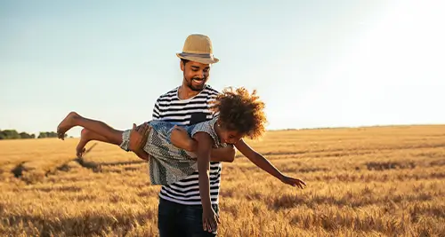 Papa jouant avec sa fille dans la nature pendant des vacances d’été en village vacances VTF en France