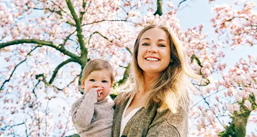 Maman tenant tendrement son bébé dans ses bras pendant les vacances en famille dans un village vacances VTF